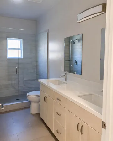 a bathroom with a double vanity sink toilet and shower