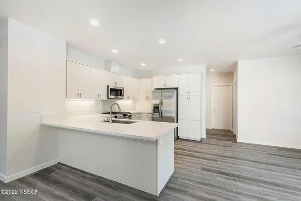 a kitchen with stainless steel appliances a refrigerator and a stove top oven