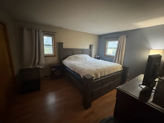 a bedroom with a bed and wooden floor