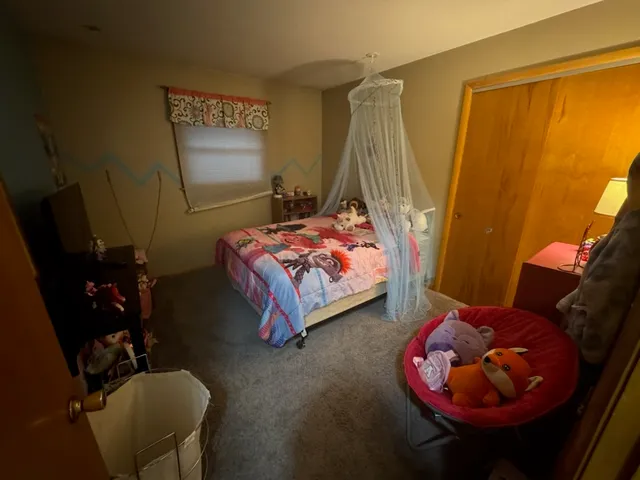 a bedroom with bed and a mirror