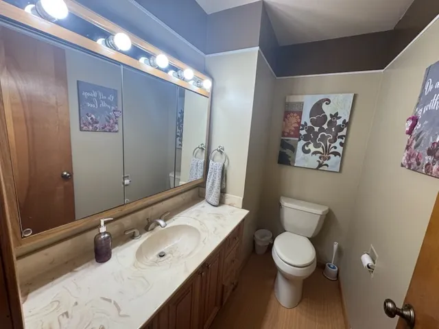 a bathroom with a granite countertop sink mirror vanity and toilet