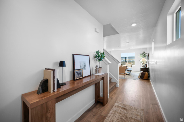 2123 Wolverine Way, Unit 2437 Washington, UT 84780 - Photo 14 of 40 Entryway featuring wood-finish flooring, a long console table, and a staircase with carpeted treads