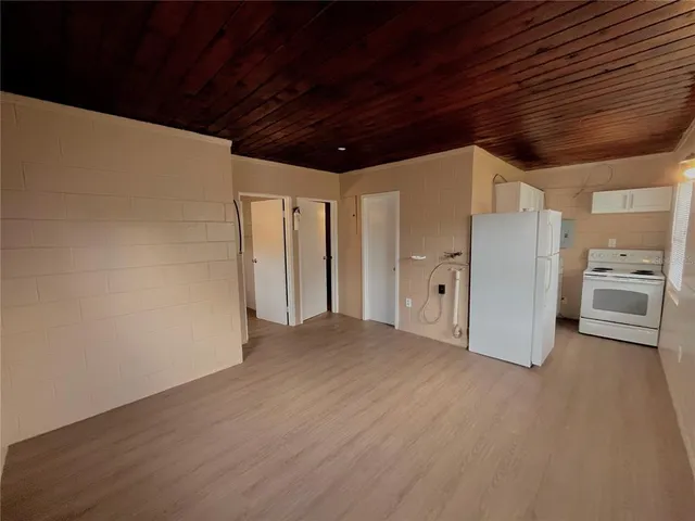 a view of an empty room with a kitchen