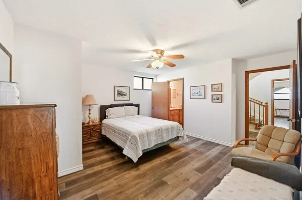 a bedroom with a bed couch and a window