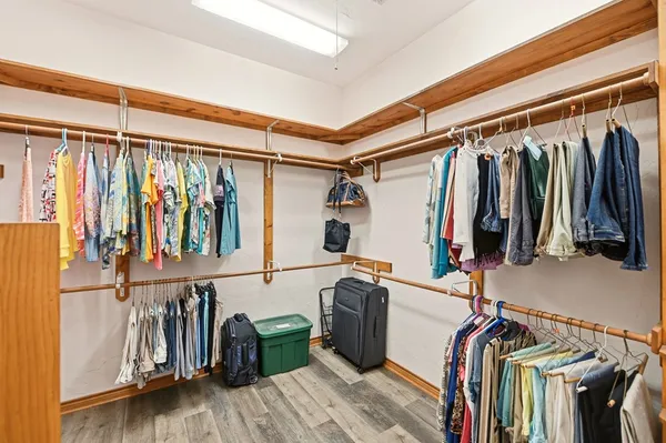 a view of walk in closet with clothes and shoes