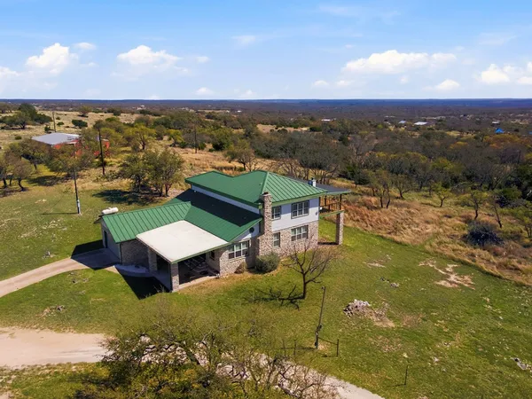 an aerial view of a house with a yard