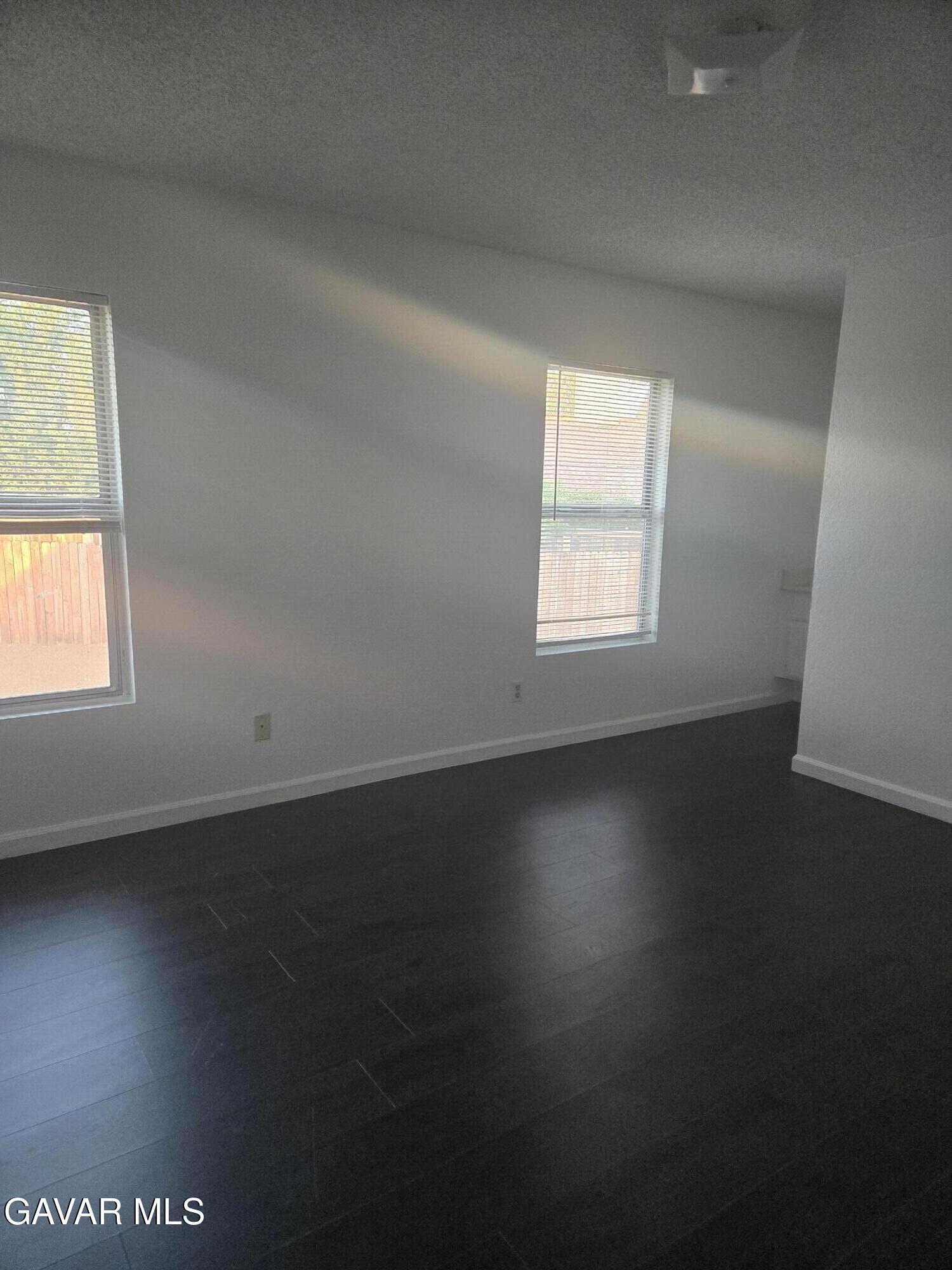 37414 Drexel Street Palmdale, CA 93550 - Photo 3 of 7 an empty room with wooden floor and windows