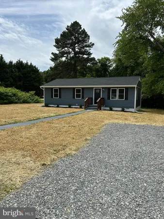a front view of house with yard and trees