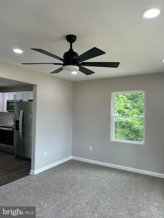 a view of a livingroom with a flesh screen tv and window