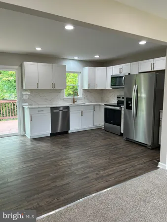 a large kitchen with stainless steel appliances granite countertop a granite counter tops and a stove