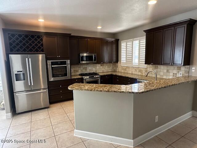 962 Balmoral Way Melbourne, FL 32940 - Photo 2 of 14 a kitchen with stainless steel appliances granite countertop a refrigerator a sink a stove a microwave a counter space and cabinets
