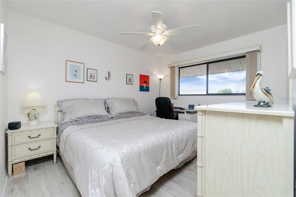 4260 Placida Road, Unit 9B Englewood, FL 34224 - Photo 16 of 38 a spacious bedroom with a bed and a chandelier