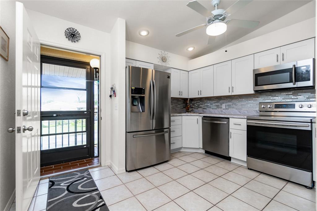 4260 Placida Road, Unit 9B Englewood, FL 34224 - Photo 2 of 38 a kitchen with granite countertop a refrigerator and a stove top oven