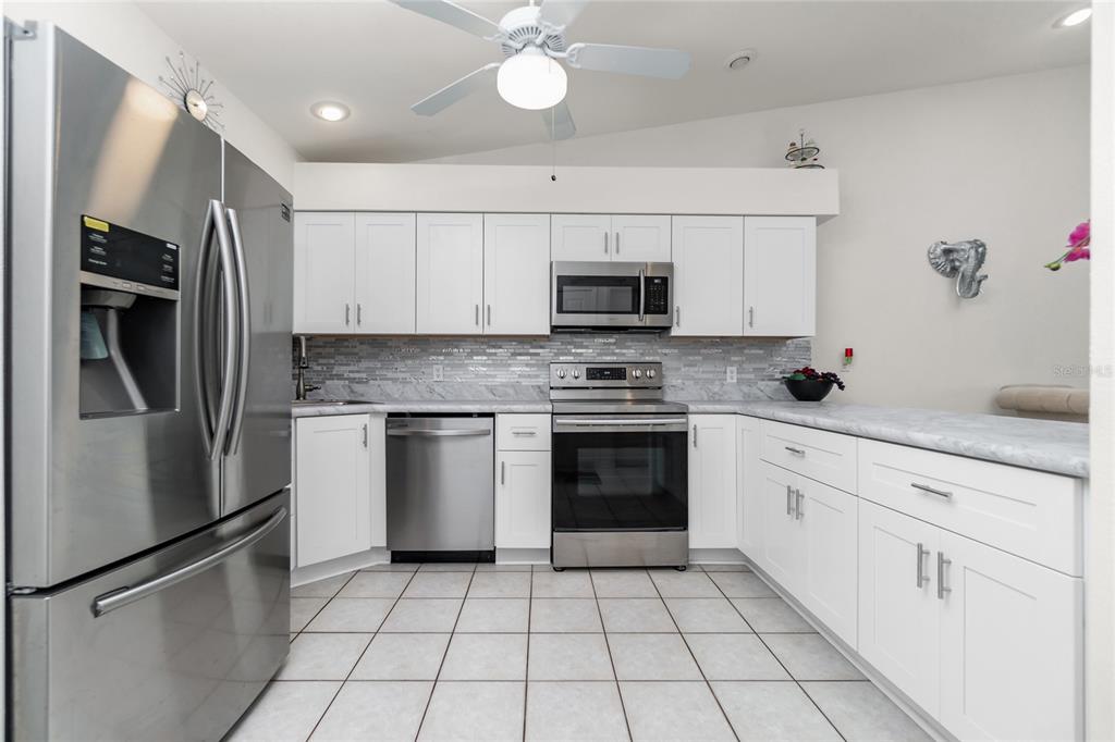 4260 Placida Road, Unit 9B Englewood, FL 34224 - Photo 4 of 38 a kitchen with stainless steel appliances a refrigerator sink and microwave