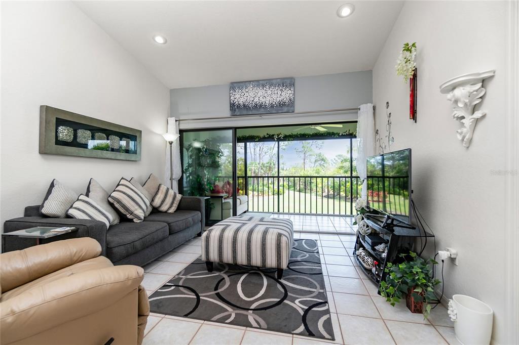 4260 Placida Road, Unit 9B Englewood, FL 34224 - Photo 8 of 38 a living room with furniture floor to ceiling window and a flat screen tv