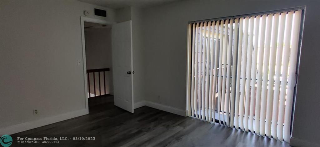 681 Springdale Circle Palm Springs, FL 33461 - Photo 13 of 17 an empty room with wooden floor and windows