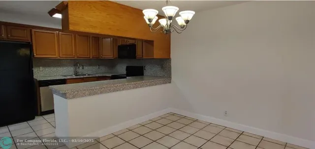 a view of a chandelier fan and kitchen view