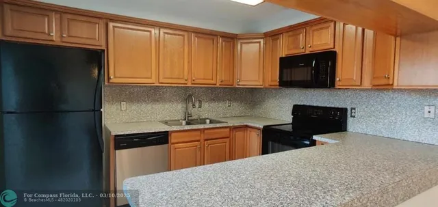 a kitchen with granite countertop a sink a stove and cabinets