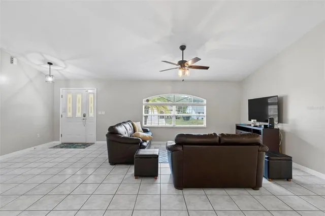a view of a dining room and livingroom with furniture wooden floor a chandelier