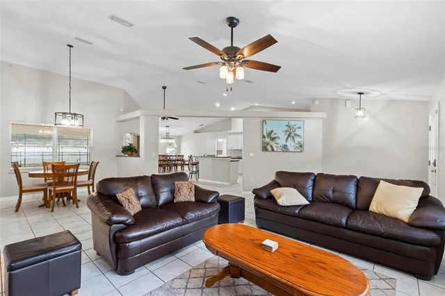 a kitchen with stainless steel appliances granite countertop a stove top oven a sink a dining table and chairs with wooden floor