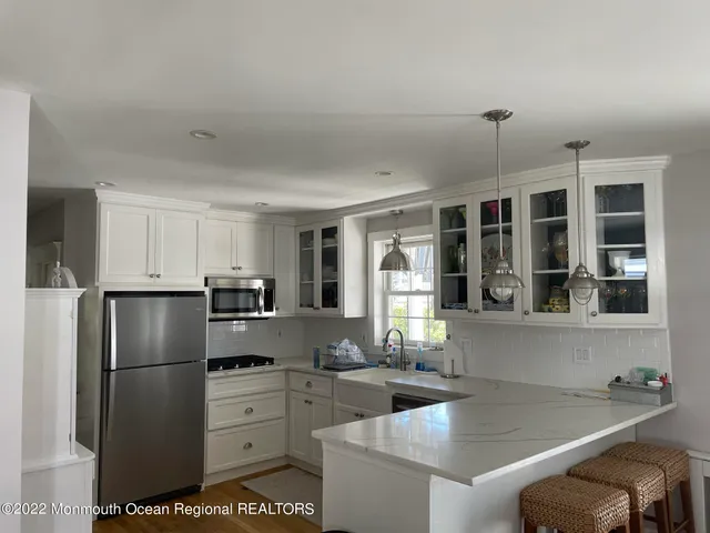 a kitchen with stainless steel appliances granite countertop a refrigerator sink and stove