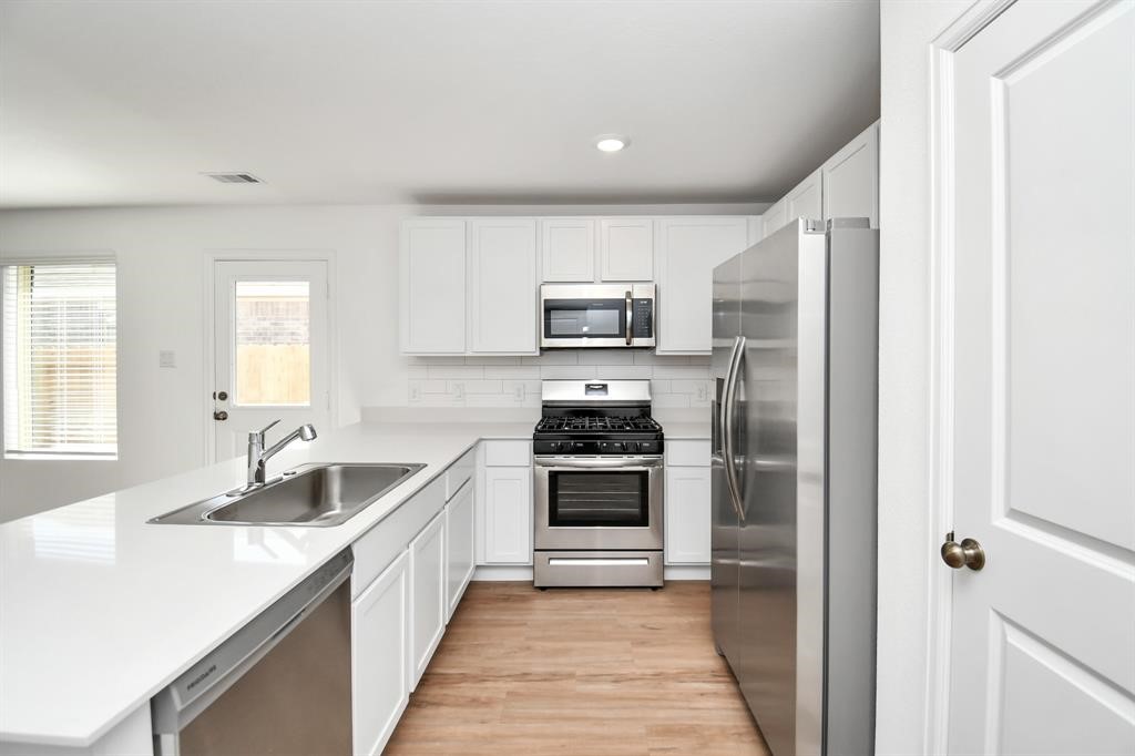 a kitchen with a sink stove and refrigerator