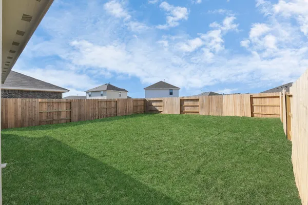 a view of a backyard with wooden fence