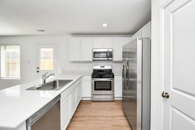 a kitchen with a sink stove and refrigerator