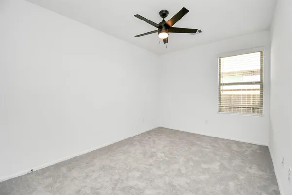 an empty room with closet and a ceiling fan