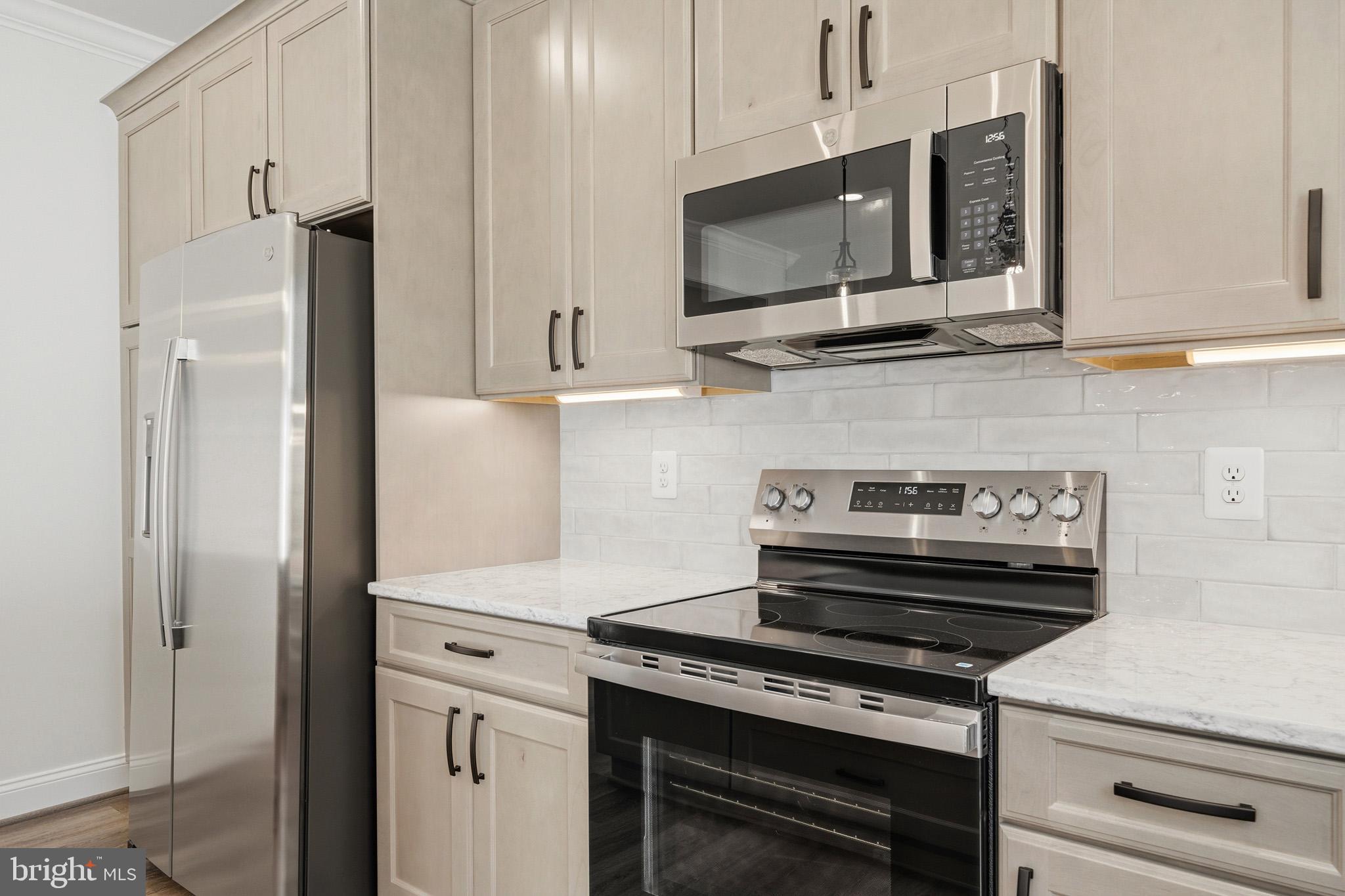 106 Potomac Court Prince Frederick, MD 20678 - Photo 13 of 47 a kitchen with stainless steel appliances a stove a microwave and cabinets
