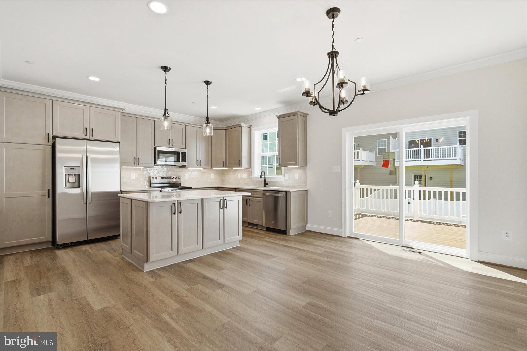 106 Potomac Court Prince Frederick, MD 20678 - Photo 5 of 47 a kitchen with stainless steel appliances kitchen island granite countertop a refrigerator a sink dishwasher a stove and white cabinets with wooden floor