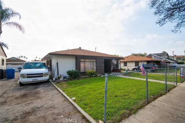 a car parked in front of a house with a yard