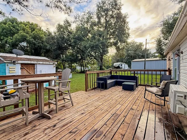 a view of a deck with table and chairs a barbeque with wooden floor and fence