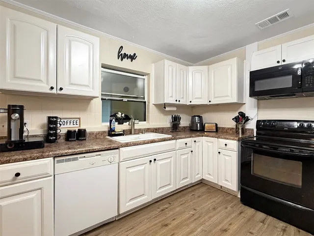 a kitchen with cabinets stainless steel appliances a sink and a microwave