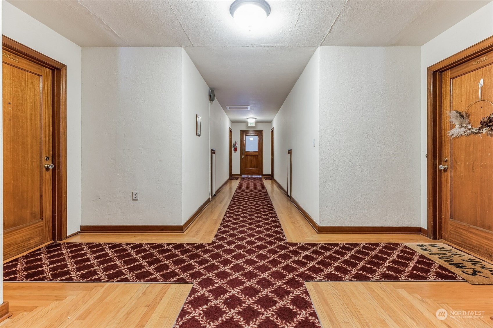 a view of a room with wooden floor and a carpet