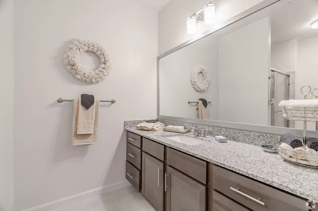 a bathroom with a granite countertop sink and a mirror