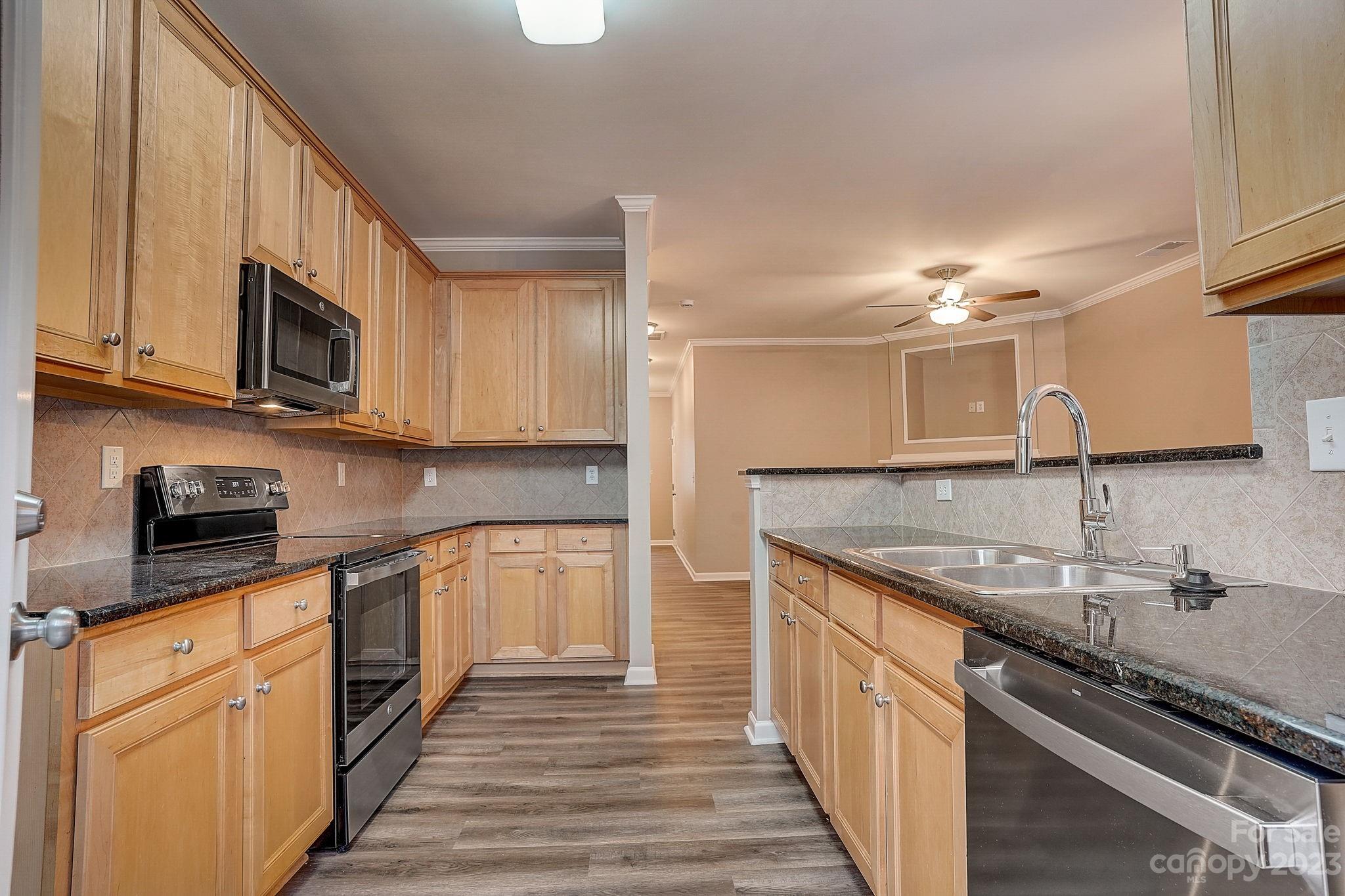 2119 Midnight Blue Lane Fort Mill, SC 29708 - Photo 5 of 15 a kitchen with stainless steel appliances granite countertop a sink stove and cabinets
