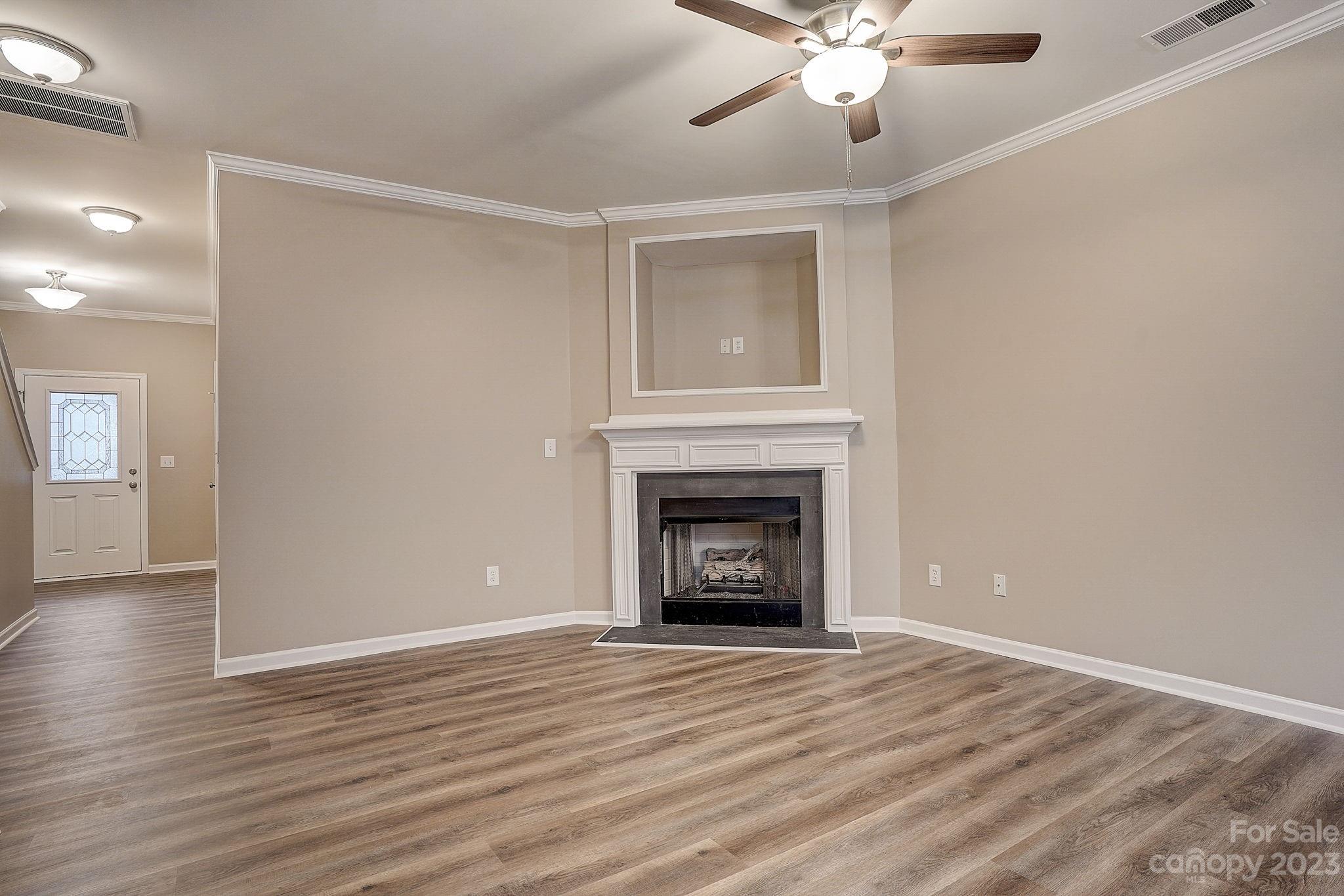 2119 Midnight Blue Lane Fort Mill, SC 29708 - Photo 6 of 15 a view of an empty room with wooden floor fireplace and a window