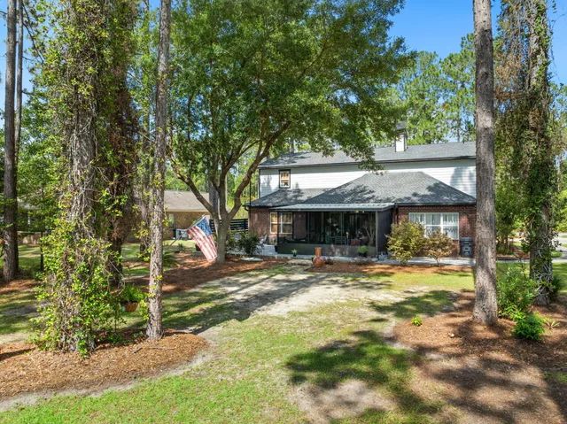 a front view of a house with a yard and green space