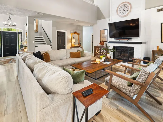 a living room with furniture a flat screen tv and a fireplace
