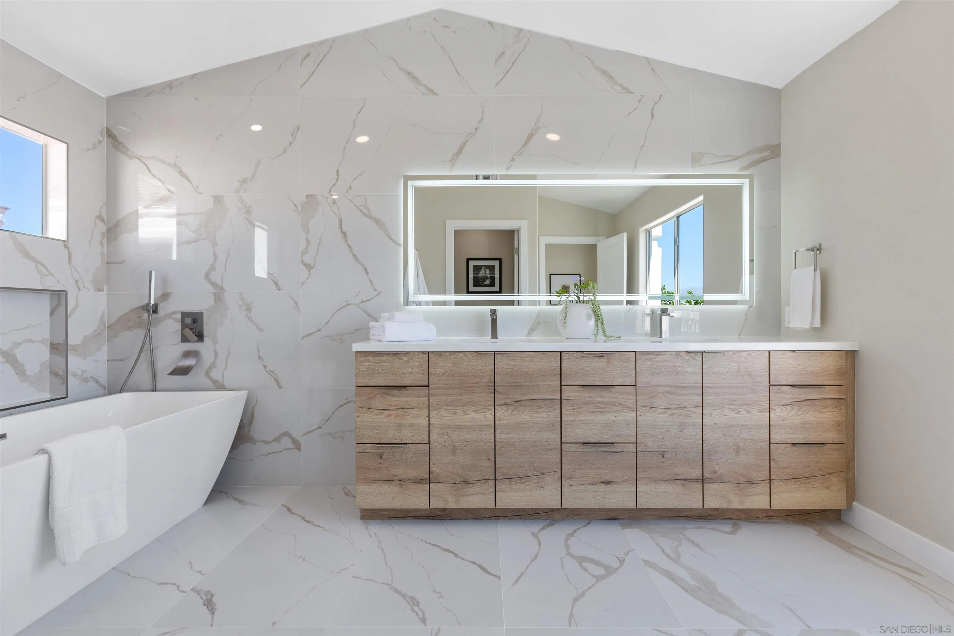 4963 Pylos Way Oceanside, CA 92056 - Photo 30 of 53 a bathroom with a double vanity sink a mirror and a bathtub