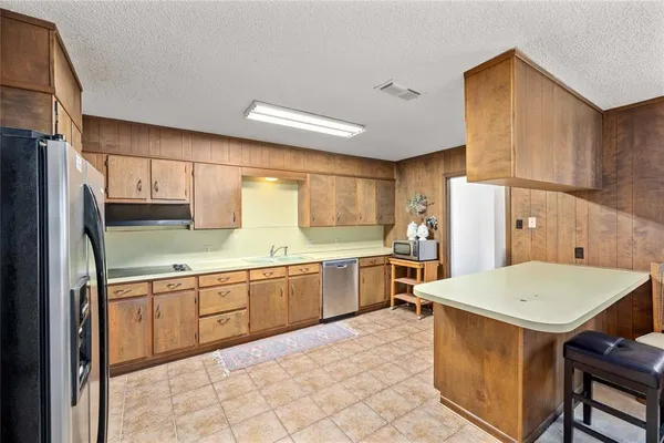 a kitchen with a sink refrigerator and cabinets