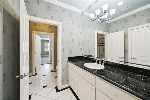 a hallway with white cabinets and wooden floor