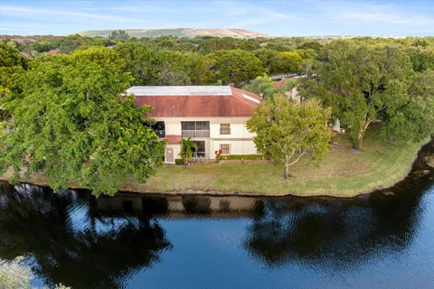 an aerial view of residential houses with outdoor space and trees