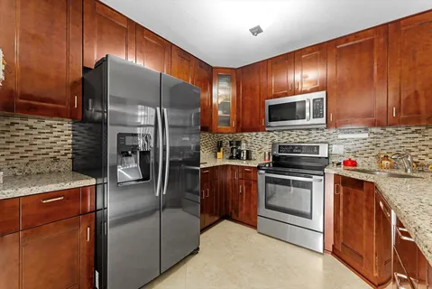 a kitchen with stainless steel appliances granite countertop a refrigerator stove and microwave