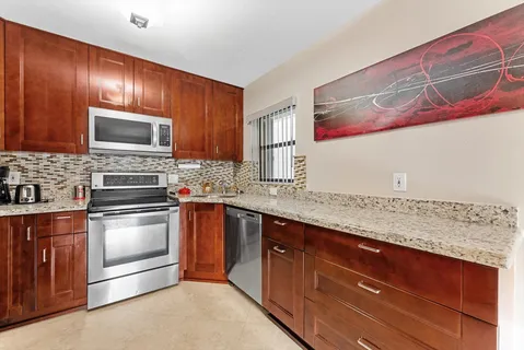 a kitchen with granite countertop stainless steel appliances and wooden cabinets