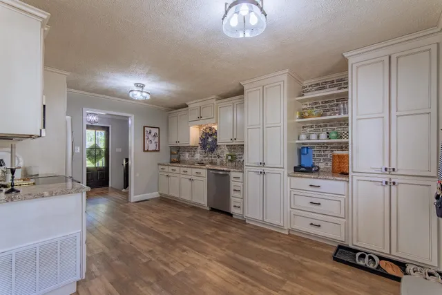 a kitchen with a refrigerator cabinets and wooden floor