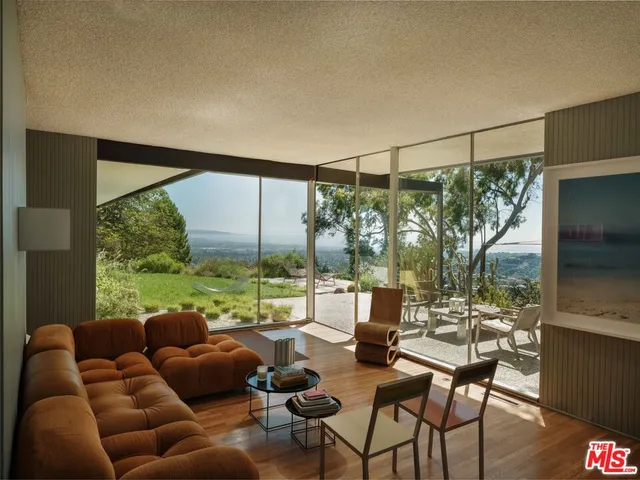a living room with furniture and a floor to ceiling window