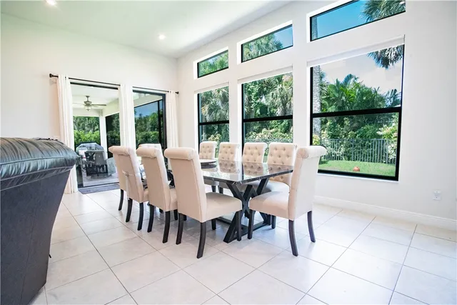 a dining room with furniture and a floor to ceiling window