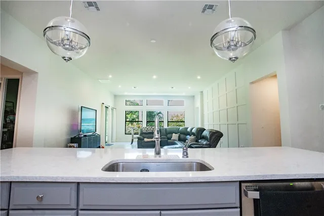 a view of a counter top a sink and chandelier